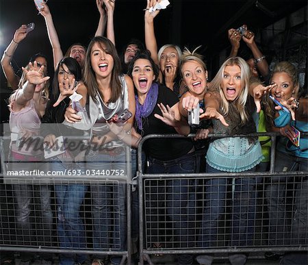 Fans leaning over barrier and screaming