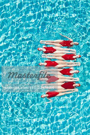 Synchronised swimmers balance head-to-toe
