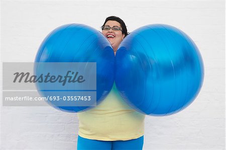 Happy Overweight Woman Holding Exercise Balls