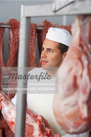 Butcher holding slab of meat, Working in Meat Locker