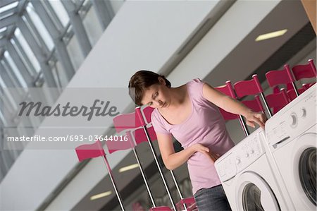 Young woman measures washing machine in shopping mall, Voronezh