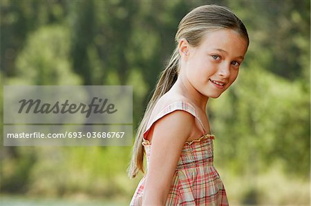 Girl (7-9) standing outdoors, portrait.
