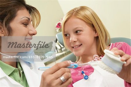 Girl (7-10) with dentist in surgery