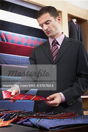 Businessman selecting tie in clothes store