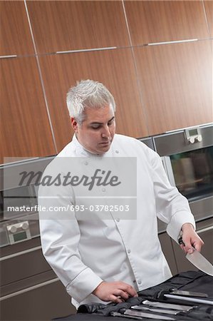 Mid- adult chef chooses knife