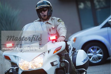 Patrol officer sits on motorcycle with hazrd lights lit