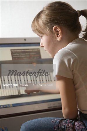 Child leans keywboard on computer with touch screen technology