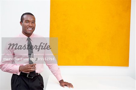 Portrait of smiling young man in front of painting
