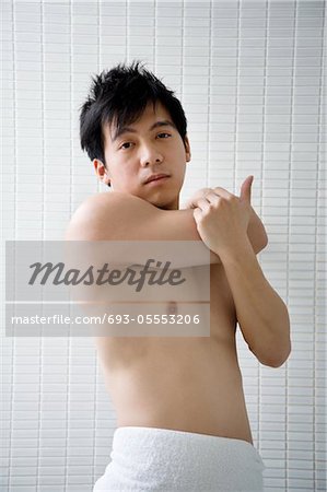 Portrait of young man in bathroom stretching