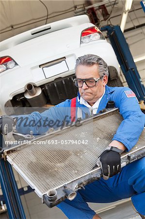 Mechanic working on an auto part of an car with a wrench