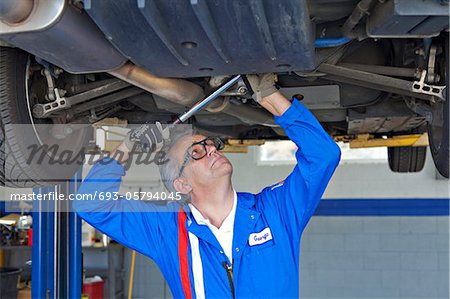 Mechanic repairing the car with a monkey wrench