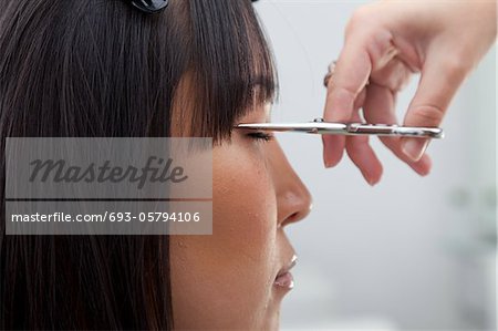 Close-up view of hairstylist cutting hair