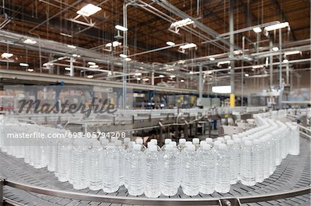 Bottled water on conveyor at bottling plant Bottled water on conveyor at bottling plant