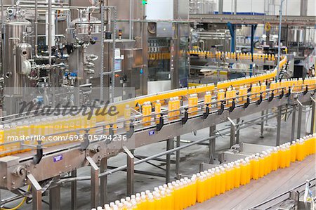Juice bottles moving along the conveyor belt Juice bottles moving along the conveyor belt