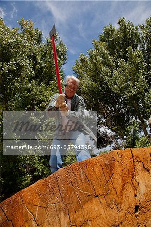 Low angle view of man about to chop wood