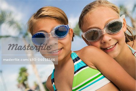 Two girls (7-9) wearing swim goggles, portrait.