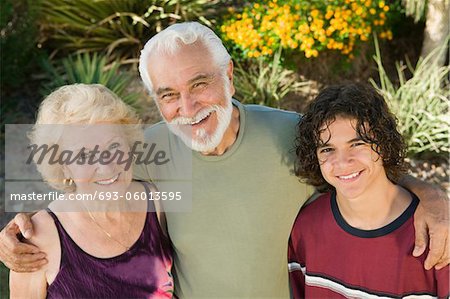 Teenage boy (13-15) with grandparents outdoors, elevated view portrait.