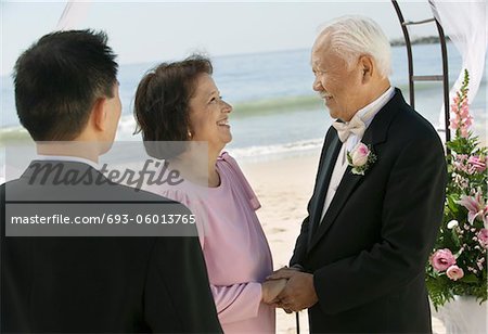 Groom with parents at beach wedding