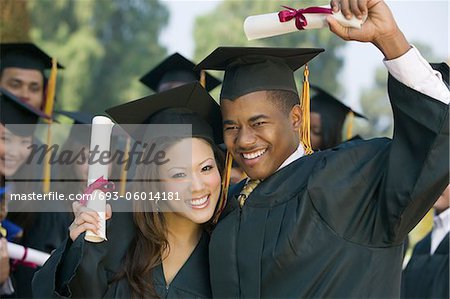 Graduates hoisting diplomas outside