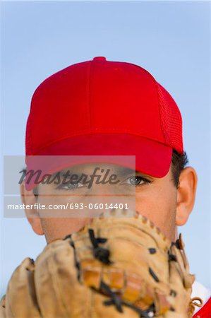 Baseball pitcher holding glove in front of face, (close-up), (portrait)