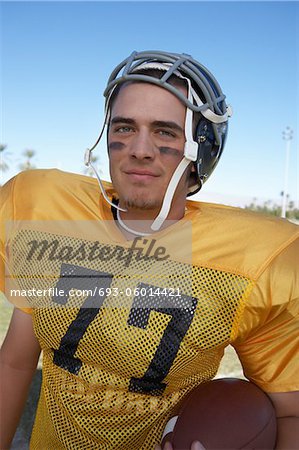 Player Holding Football on field, portrait, (portrait)