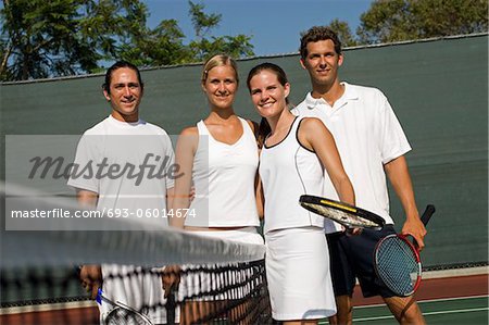 Mixed Doubles Tennis Players standing at Net, arms around