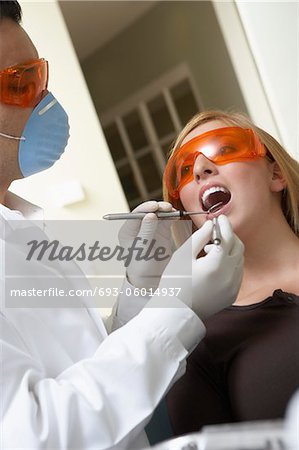 Dentist examining womans teeth in surgery