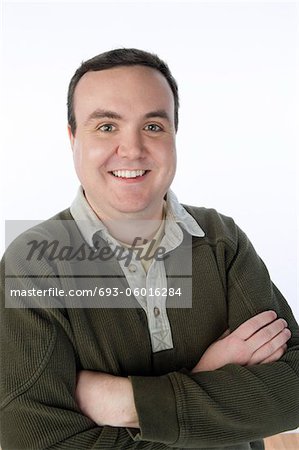 Overweight mid-adult man standing with arms crossed, portrait