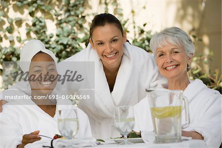 Portrait of three women in bathrobes at health spa