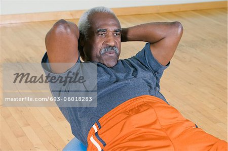 Senior Man Doing Sit-Ups on Exercise Ball