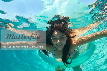 Young woman swimming in pool, underwater view