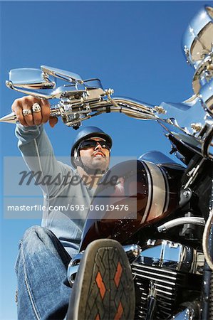 Biker riding motorcycle, low angle view