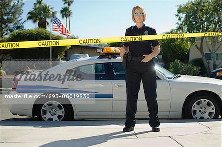 Police Officer Standing Behind Police Tape