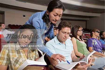 Female teacher assisting students during lesson
