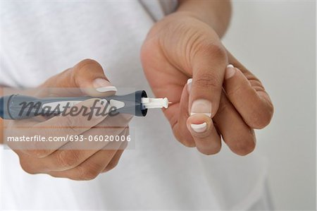 Woman injecting insulin using syringe, close-up of hands