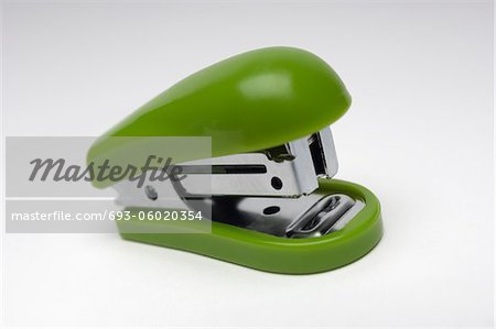 Green stapler on white background