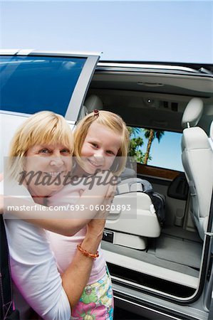 Mother Hugging Daughter by Minivan