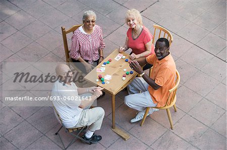 Senior people playing cards, smiling