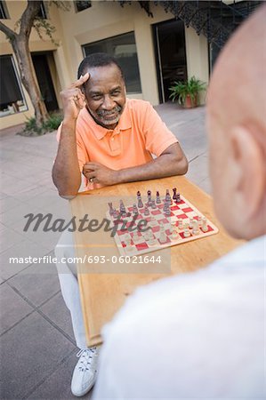 Two senior men playing chess