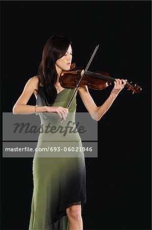 Young Asian woman stands playing the violin