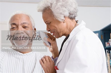 Senior medical practitioner takes patient's temperature