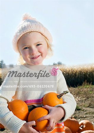Portrait of a girl holding pumpkins