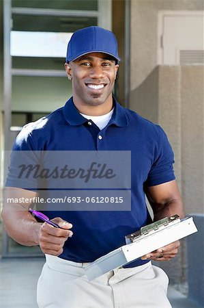 Portrait of a happy young African American delivery man with clipboard