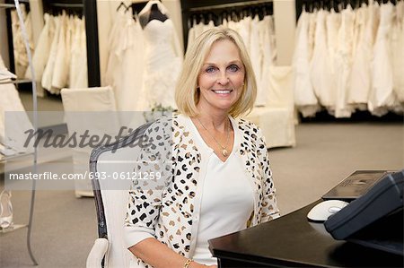 Portrait of a happy senior woman sitting in bridal store