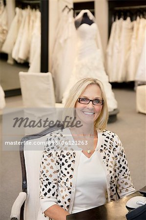 Portrait of a happy woman sitting on chair in bridal store