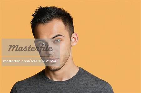 Portrait of a confident young man over colored background