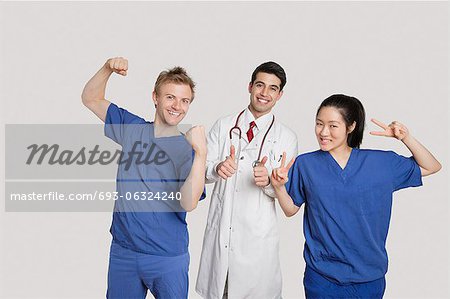 Portrait of a cheerful medical team gesturing over gray background