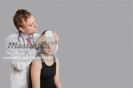 Doctor adjusting bandage on patient's head