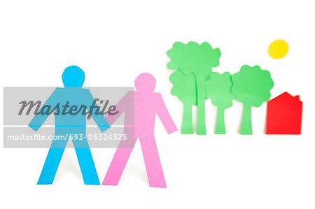 Paper cut outs representing a couple with trees and house over white background