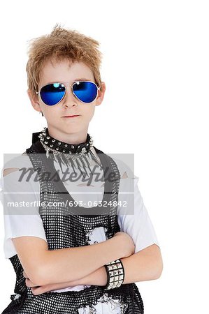 Portrait of punk pre-teen boy wearing sunglasses with arms crossed